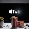 Apple TV+ logo on a TV screen, with popcorn and a remote.