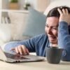 Woman crying while using a laptop.