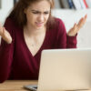 A woman getting frustrated by her laptop