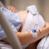Pregnant woman in hospital bed experiencing contractions.