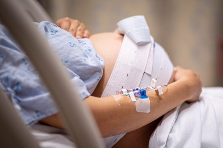 Pregnant woman in hospital bed experiencing contractions.