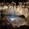 Tourists explore the 'Dome of the Cathedral', the largest chamber in Grutas Tzabnah, Yucatán, Mexico