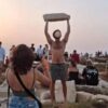 Tourist hold ancient stone aloft at Naxos, Greece.