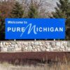 Welcome sign for Pure Michigan with a blue background and stone base