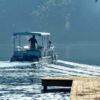 Two people on a boat navigating a misty lake