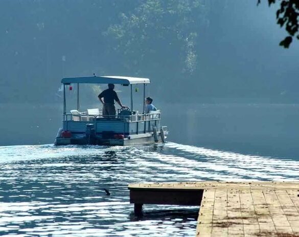 Two people on a boat navigating a misty lake