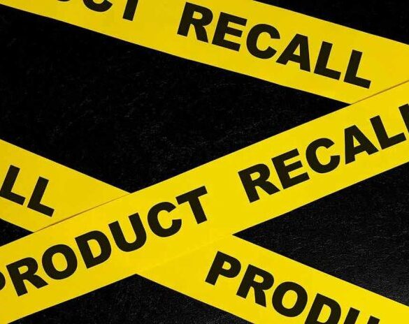 Yellow tape with product recall text on black background.