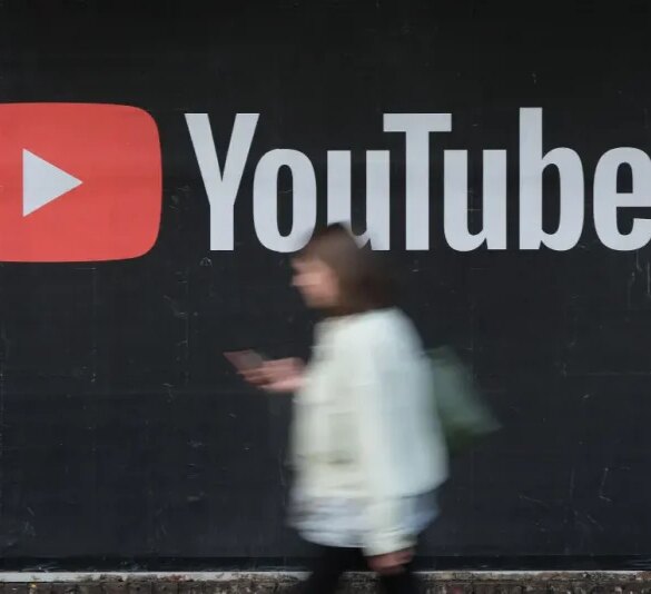 BERLIN, GERMANY - SEPTEMBER 27: A young woman with a smartphone walks past a billboard advertisement for YouTube on September 27, 2019 in Berlin, Germany. YouTube has evolved as the world's largest platform for sharing video clips. (Photo by Sean Gallup/Getty Images)