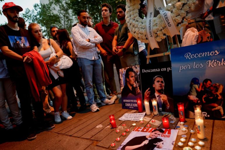 People mourning U.S. right-wing activist and commentator Charlie Kirk outside the U.S. embassy in Madrid, with candles and images of Kirk.