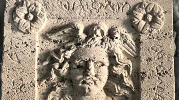 Burial urn with Medusa relief and Etruscan inscription.