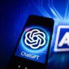 Photo illustration of a ChatGPT logo displayed on a smartphone with an AI logo in the background.