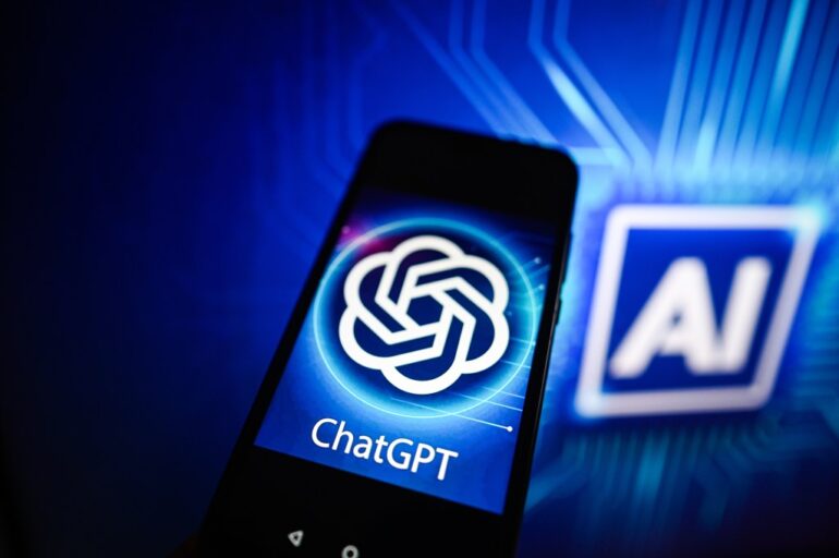 Photo illustration of a ChatGPT logo displayed on a smartphone with an AI logo in the background.