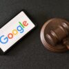 Smartphone displaying the Google logo next to a judge's gavel.