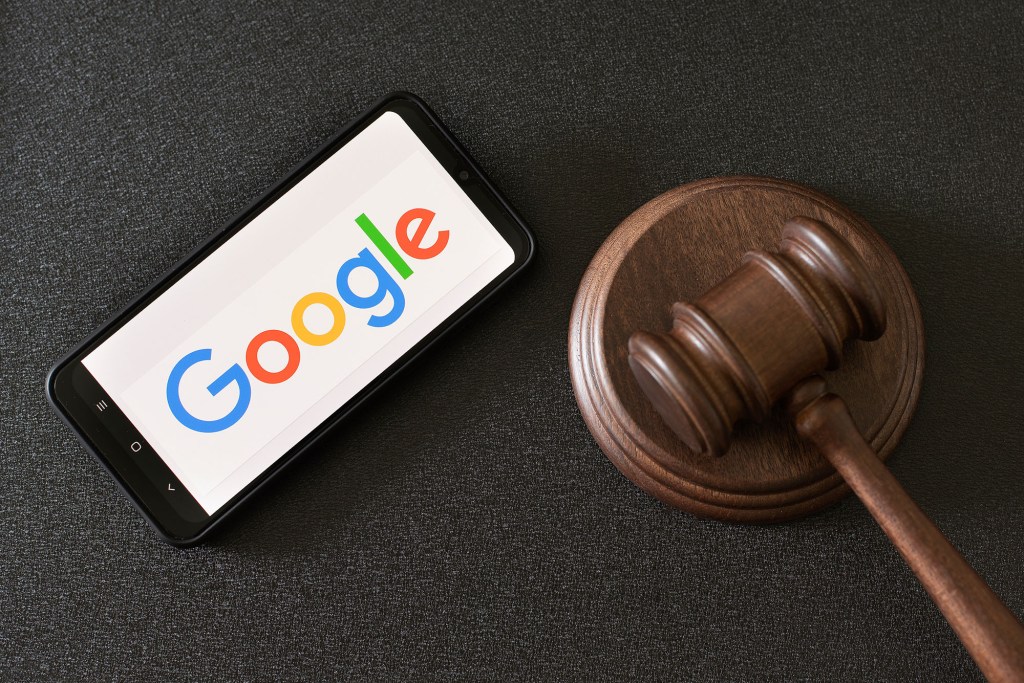 Smartphone displaying the Google logo next to a judge's gavel.