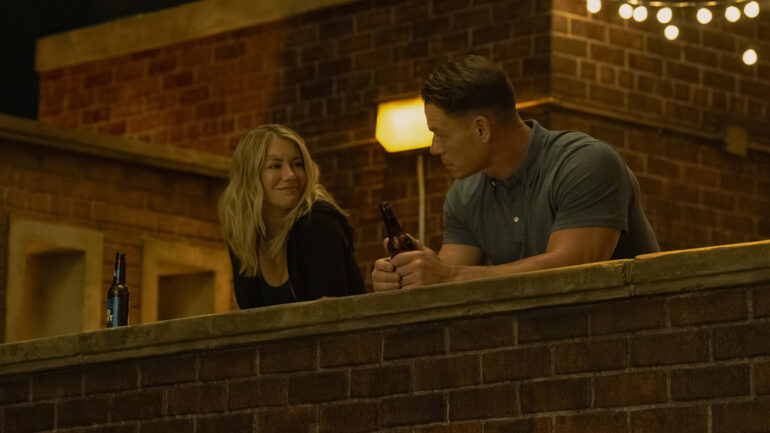 Emilia Harcourt smiling at Chris Smith at night in Peacemaker season 2