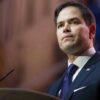 Man in suit speaking at podium.