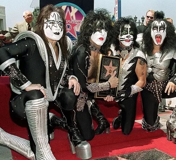 HOLLYWOOD, : Members of the rock band Kiss (from left to right): Ace Frehley, Paul Stanley, Peter Criss and Gene Simmons pose by the star they received during a Hollywood Walk of Fame ceremony 11 August 1999 in Hollywood, Ca. The group, known for their theatrical stage performances, has sold 80 million records over their 26 year career. AFP PHOTO/Vince BUCCI (Photo credit should read Vince Bucci/AFP via Getty Images)
