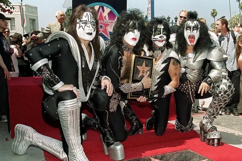 HOLLYWOOD, : Members of the rock band Kiss (from left to right): Ace Frehley, Paul Stanley, Peter Criss and Gene Simmons pose by the star they received during a Hollywood Walk of Fame ceremony 11 August 1999 in Hollywood, Ca. The group, known for their theatrical stage performances, has sold 80 million records over their 26 year career. AFP PHOTO/Vince BUCCI (Photo credit should read Vince Bucci/AFP via Getty Images)