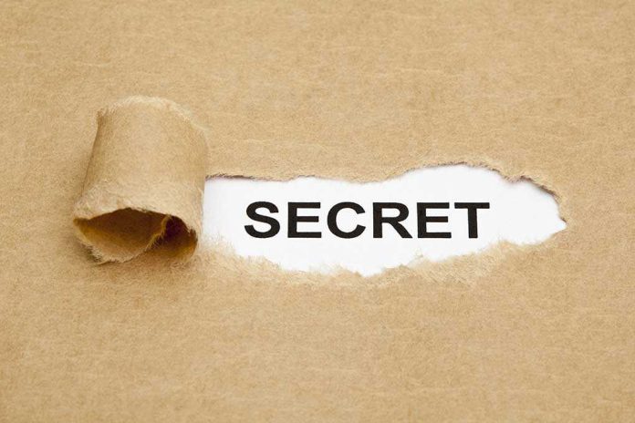 A torn piece of brown paper revealing the word SECRET underneath