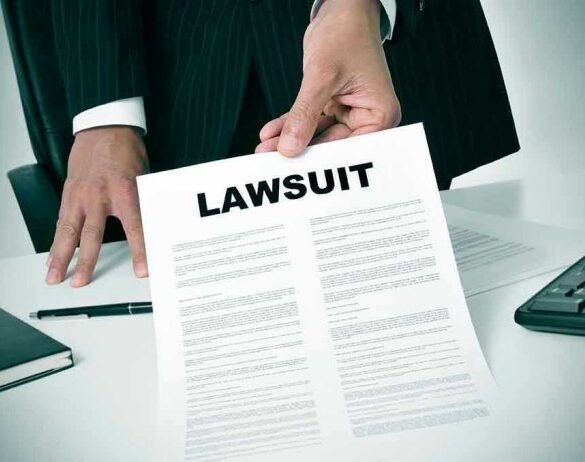 Person holding a document titled LAWSUIT in office.