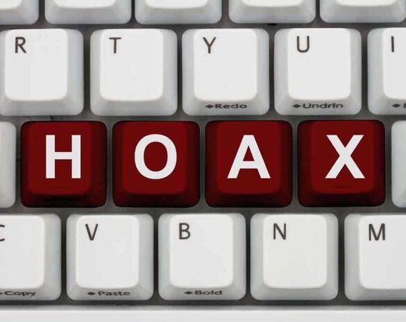 Close-up of a computer keyboard with the word HOAX spelled out in red keys