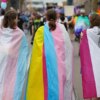 BERLIN, GERMANY - JULY 26: (L-R) Participants draped in the Transgender flag, Pan-sexual flag and asexual flag as the march during the 2025 Christopher Street Day CSD Berlin Pride march on July 26, 2025 in Berlin, Germany. The 47th Berlin CSD is taking place under the motto "Never be silent again!" (Photo by Omer Messinger/Getty Images)