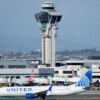 LOS ANGELES, CALIFORNIA - OCTOBER 22: A United plane taxis in front of the air traffic control tower at Los Angeles International Airport on October 22, 2025 in Los Angeles, California. The Secretary of Transportation stated yesterday that air traffic controllers could stop receiving a paycheck next week while the federal government shutdown continues. (Photo by Mario Tama/Getty Images)