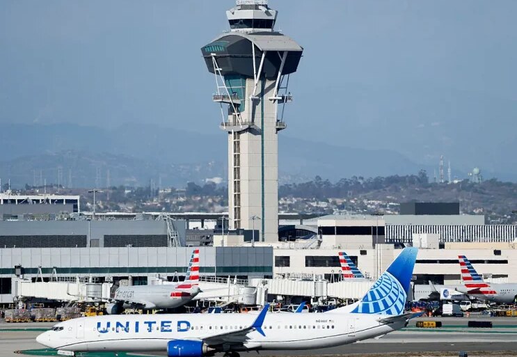 LOS ANGELES, CALIFORNIA - OCTOBER 22: A United plane taxis in front of the air traffic control tower at Los Angeles International Airport on October 22, 2025 in Los Angeles, California. The Secretary of Transportation stated yesterday that air traffic controllers could stop receiving a paycheck next week while the federal government shutdown continues. (Photo by Mario Tama/Getty Images)