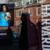 Harvard University is reflected in the window of a merchandise store across the street from the school on April 17, 2025 in Cambridge, Massachusetts. The Trump administration announced that it would block Harvard University from receiving $2.2 billion in federal grants and $60 million in contracts after the school refused demands to adopt new policies relating to student and faculty conduct, admissions, anti-semitism on campus and DEI. (Photo by Sophie Park/Getty Images)