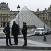 French police officers stand in front of the Louvre Museum after robbery, in Paris on October 19, 2025. Robbers broke in to the Louvre and fled with jewellery on October 19, 2025 morning, a source close to the case said, adding that its value was still being evaluated. A police source said an unknown number of thieves arrived on a scooter armed with small chainsaws and used a goods lift to reach the room they were targeting. (Photo by Dimitar DILKOFF / AFP) / -- IMAGE RESTRICTED TO EDITORIAL USE - STRICTLY NO COMMERCIAL USE -- (Photo by DIMITAR DILKOFF/AFP via Getty Images)