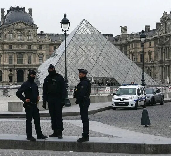 French police officers stand in front of the Louvre Museum after robbery, in Paris on October 19, 2025. Robbers broke in to the Louvre and fled with jewellery on October 19, 2025 morning, a source close to the case said, adding that its value was still being evaluated. A police source said an unknown number of thieves arrived on a scooter armed with small chainsaws and used a goods lift to reach the room they were targeting. (Photo by Dimitar DILKOFF / AFP) / -- IMAGE RESTRICTED TO EDITORIAL USE - STRICTLY NO COMMERCIAL USE -- (Photo by DIMITAR DILKOFF/AFP via Getty Images)