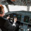 Pilot in cockpit operating airplane controls.
