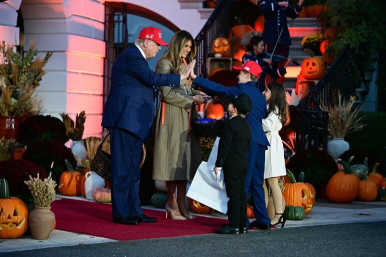 US President Donald Trump high-fives a boy as he and First Lady Melania Trump host a Halloween event at the White House in Washington, DC, on OCtober 30, 2025. (Photo by Jim WATSON / AFP) (Photo by JIM WATSON/AFP via Getty Images)