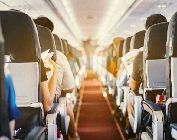 Passengers seated inside an airplane cabin.