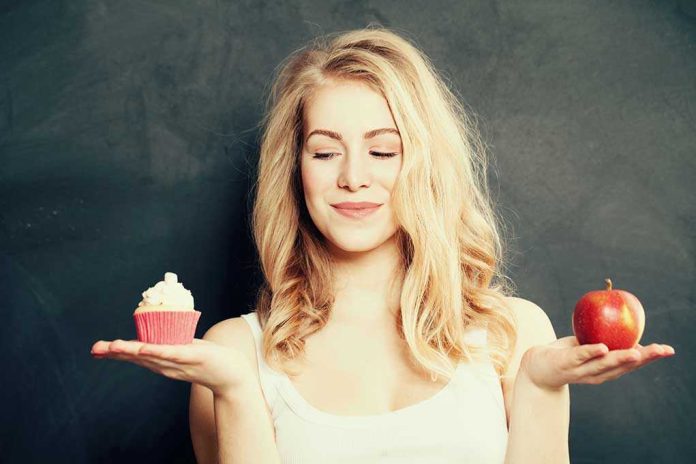 Woman holding a cupcake and an apple