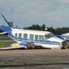 Damaged blue and white small airplane on an airport runway