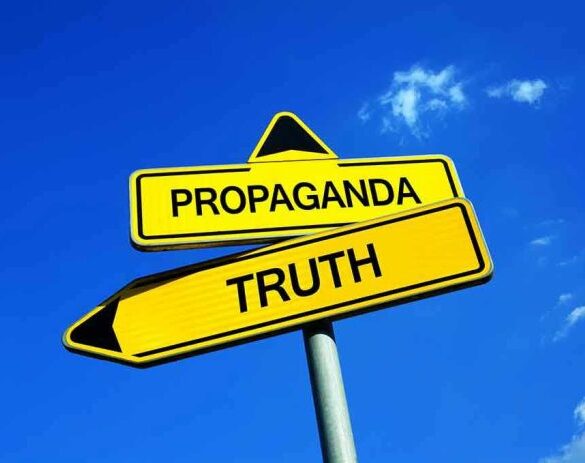 Yellow signs: Propaganda left, Truth right. Blue sky background.