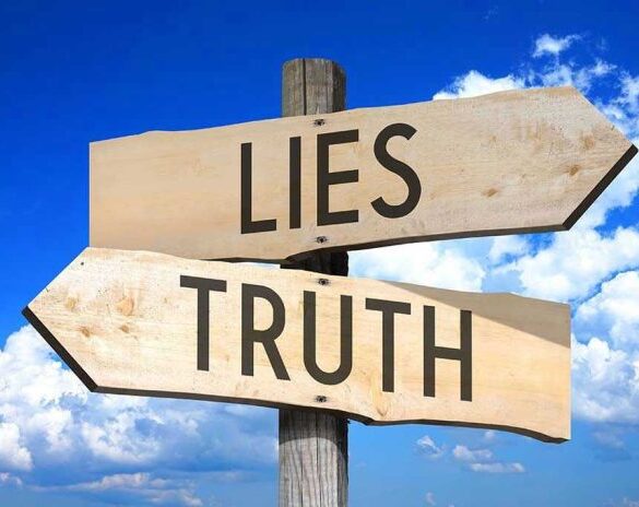 Signs pointing to Lies and Truth against sky.