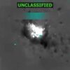 Thermal imagery showing a bright explosion with fragments scattering, and text overlays including "UNCLASSIFIED."
