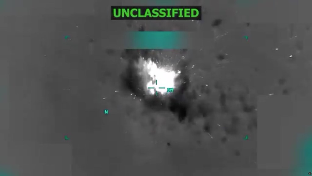 Thermal imagery showing a bright explosion with fragments scattering, and text overlays including "UNCLASSIFIED."