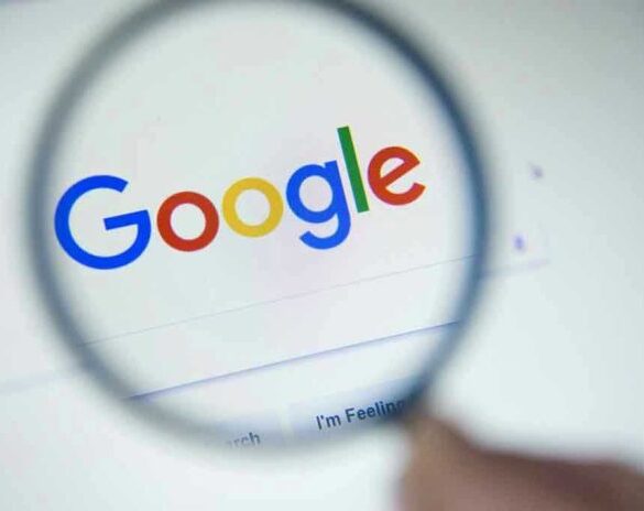Google logo viewed through a magnifying glass.
