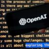 A hand holds a phone displaying the OpenAI logo over a screen showing text.
