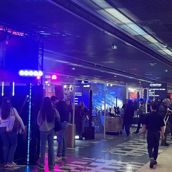 One of the halls at the Paris Audio show, lit in purple and with busy stalls