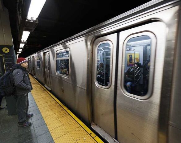 A commuter waiting at a subway station as a train approaches