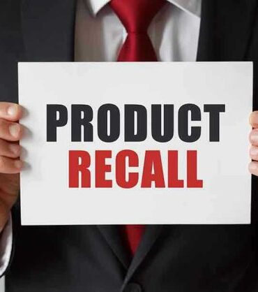 Product Recall sign held by person in suit.