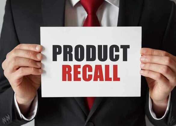 Product Recall sign held by person in suit.