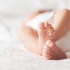 Close-up of baby feet lying on blanket.