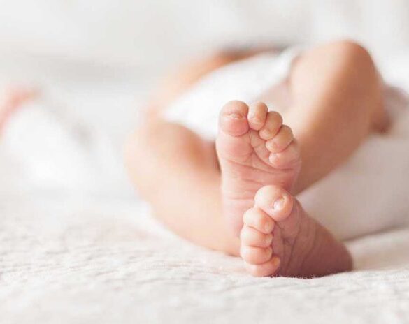 Close-up of baby feet lying on blanket.