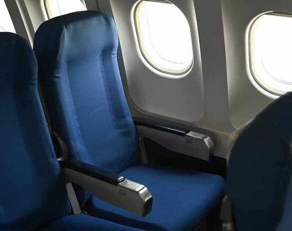 Empty airplane seats next to windows.