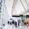 People walking in a brightly lit airport terminal.